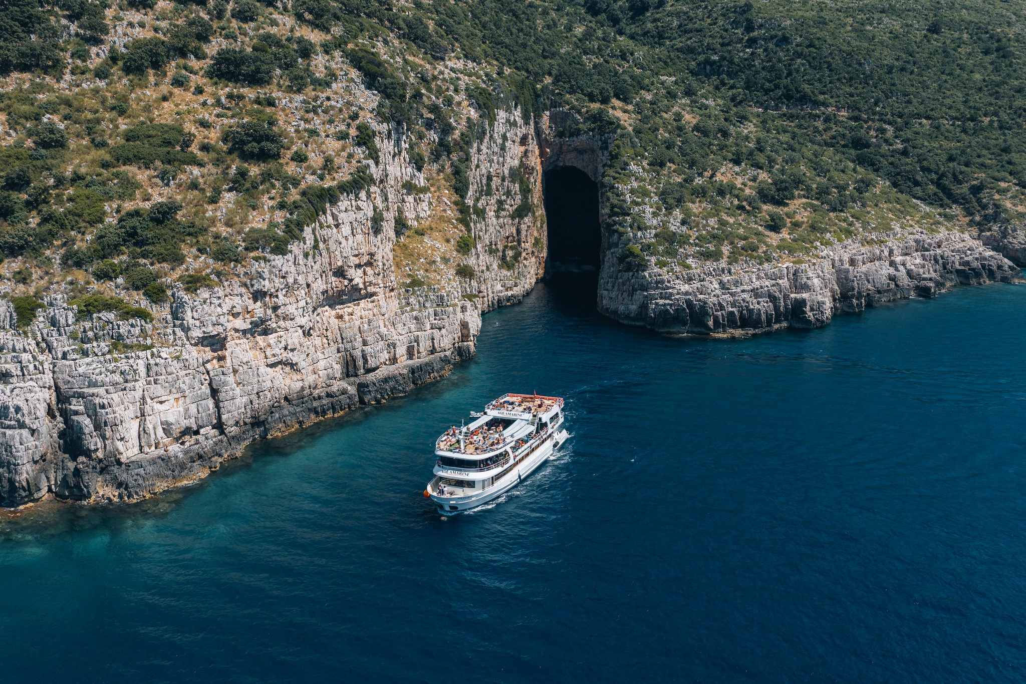 Aquamarine Adventure boat near the entrance of Haxhi Ali Cave